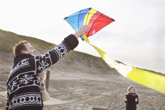 Mid adult man and son preparing to fly kite on beach, Bloemendaal aan Zee, Netherlands