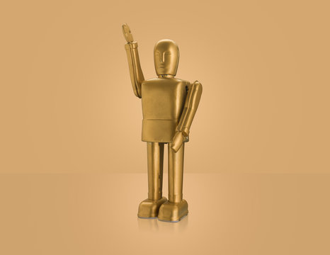 Studio shot of gold robot with arm raised