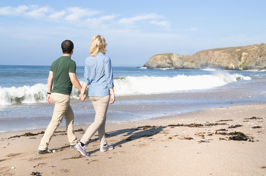 Mid adult couple walking on beach, Thurlestone, Devon, UK