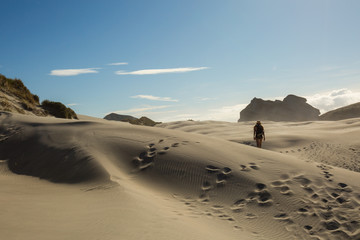 Fototapeta na wymiar Woman traveler walking on sand dune