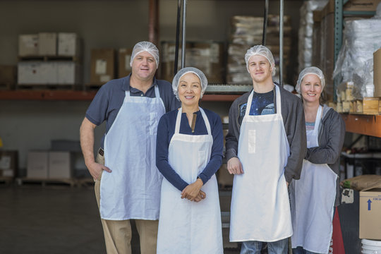 Portrait of four factory workers smiling
