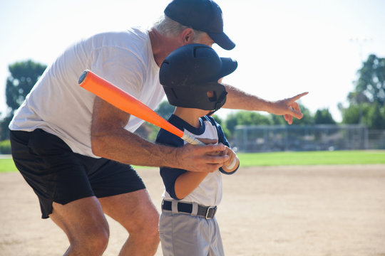 Man teaching grandson to play baseball