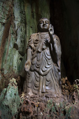 Fototapeta na wymiar Sculpture of standing Buddha in the cave Tang Chon full face. Marble mountain, Danang, Vietnam