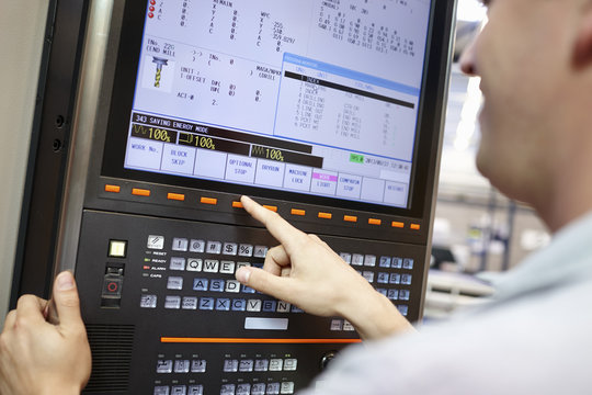 Worker checking computer monitor in engineering factory