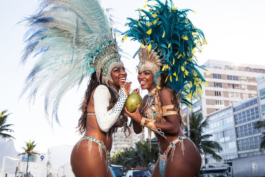 Samba dancers drinking coconut drink, Ipanema Beach, Rio De Janeiro, Brazil