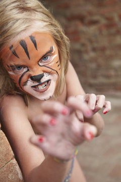 Girl with face painting imitating tiger