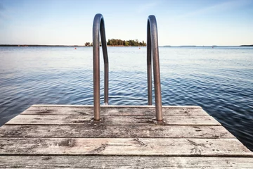 Badkamer foto achterwand Pier Houten pier om te zwemmen aan de kust van een meer