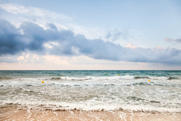Surf on sandy Mediterranean beach at morning