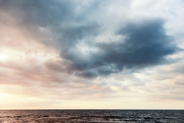 Naklejka na ściany i meble Colorful dramatic sky with clouds over sea water