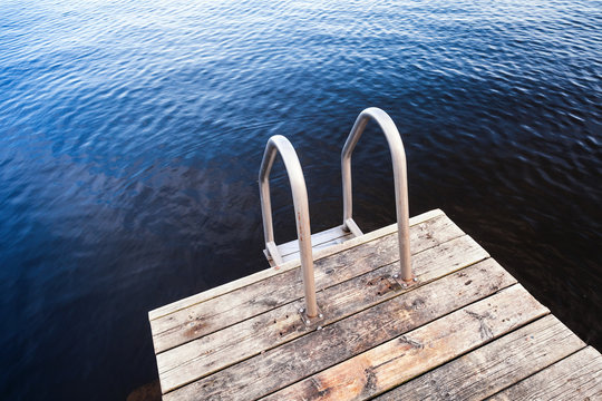 Fototapeta Deep blue water and wooden pier for swimming