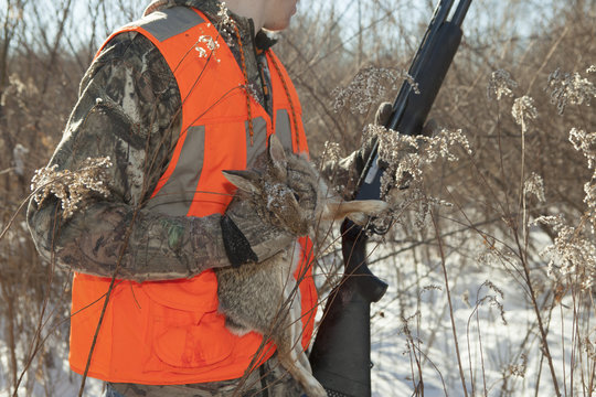 Teenage boy holding dead rabbit in Petersburg State Game Area, Michigan, USA