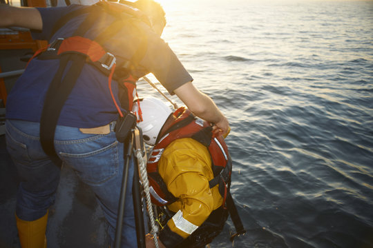 Lifeboat crew training and pulling up team member from sea