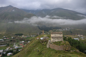 Sioni Basilica and watchtower above valley and Military Georgian highway in cloudy weather,...