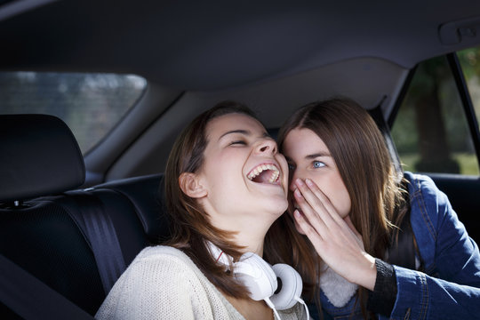 Sisters whispering in car
