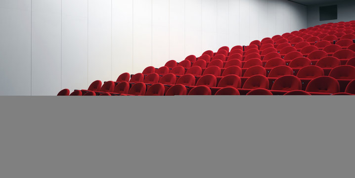 Red chairs in empty auditorium