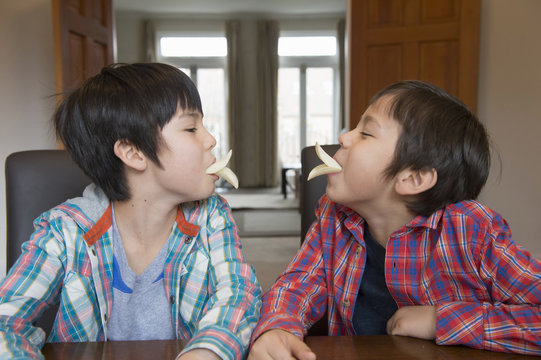 Brothers imitating bird beak with crisps