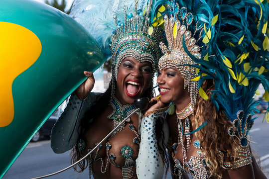 Samba dancers using pay phone, Ipanema Beach, Rio De Janeiro, Brazil
