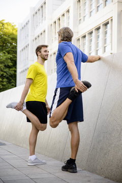 Two men stretching hamstrings