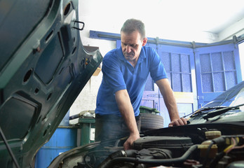 Mechanic checking car engine
