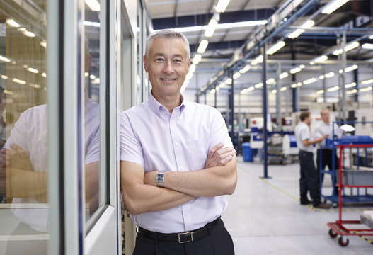 Portrait of manager with arms folded in engineering factory