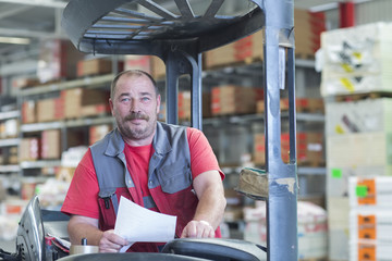 Portrait of forklift truck driver in hardware store warehouse