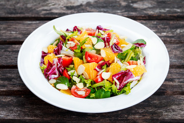 Fresh Orange, vegetables salad on wooden table.