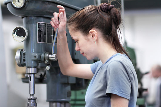 Female engineer using machine in workshop