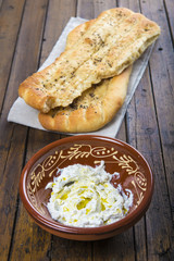 Pan plano persa con semillas de sésamo y queso fresco tipo labneh con aceite de oliva, comida tradicional de oriente medio