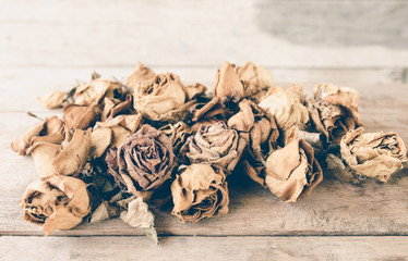 Wilted roses on wooden table