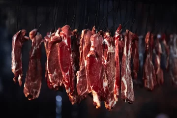 Crédence de cuisine en verre imprimé Viande meat in a smokehouse, the meat on hooks