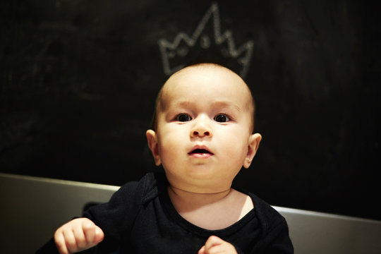 Portrait of baby boy with artist chalked crown on head