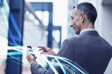 Waves of blue light and businessman using touchscreen on smartphone