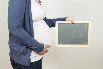 Schwangere hält Tafel