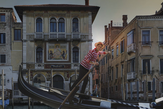 Gondolier on Grand canal, Venice, Veneto, Italy