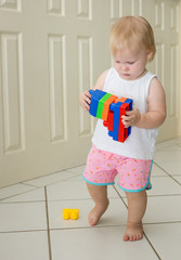 Toddler walking and playing with blocks
