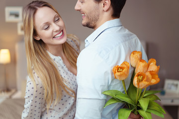 mann versteckt einen strauß tulpen hinter dem rücken