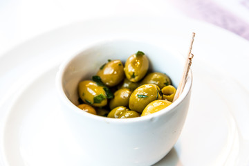 green olives in white bowl on table