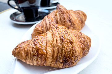 Breakfast with coffee and croissants on table