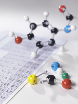 Molecular model next to periodic table on lab bench
