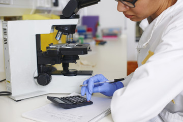Female scientist using calculator
