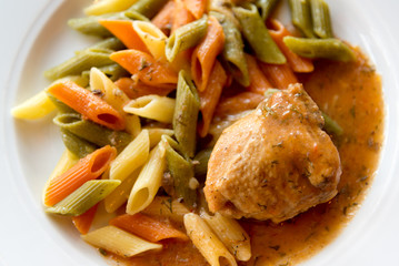colored pasta with chicken on plate
