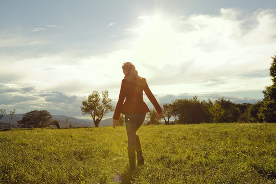 Young woman in field walking away