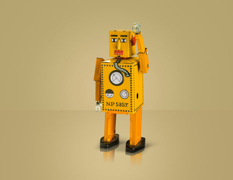 Studio shot of yellow robot with arm raised