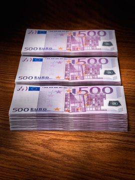 Three stacks of 500 euro bills on office desk