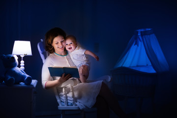 Mother reading a book to little baby