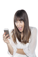 Portrait of an amazed woman reading a text message against a white background