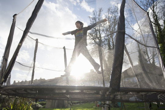 Boy jumping on outdoor trampoline