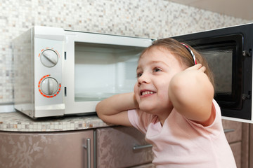 child without supervision of parents near microwave