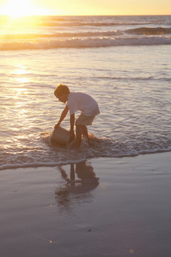 Boy fetching sea water with bucket