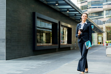 Portrait of business woman walking and smiling outdoor